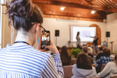 Una partecipante fotografa il palco durante un intervento